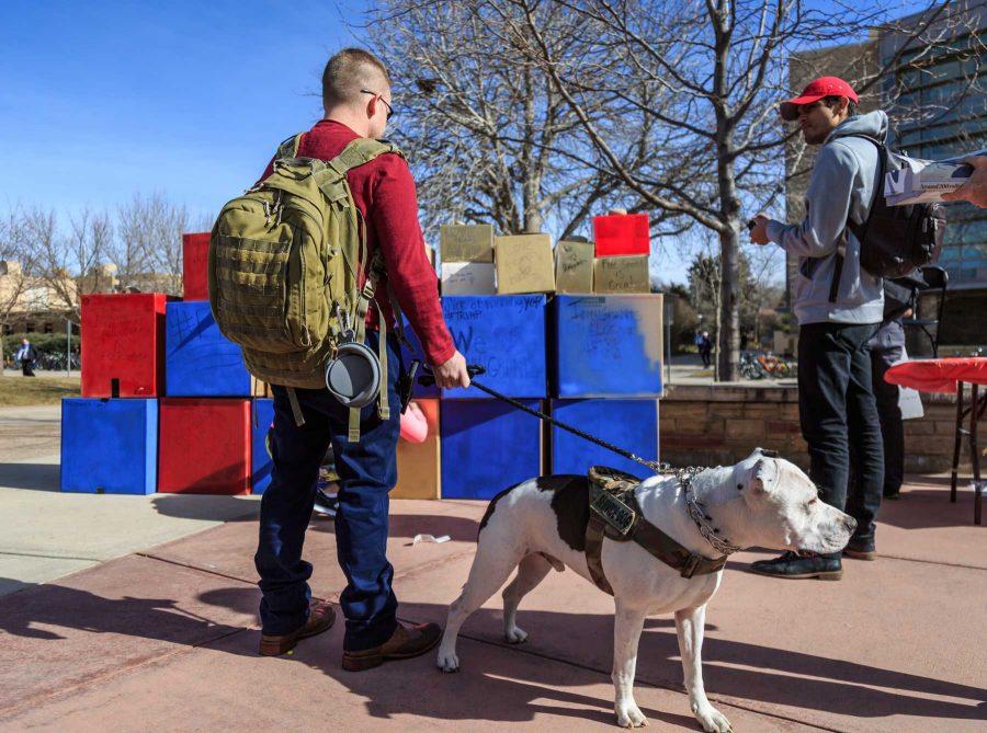 A passerby observes College Republicans at CSU's 'Free Speech Wall' during the "To Immigrants With Love" event hosted by Dreamers United. February 8, 2017 (Davis Bonner | Collegian)
