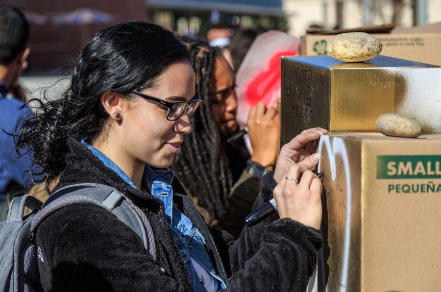 A student writes a message on College Republicans at CSU's 'Free Speech Wall' during the "To Immigrants With Love" event on the plaza. February 8, 2017 (Davis Bonner | Collegian)