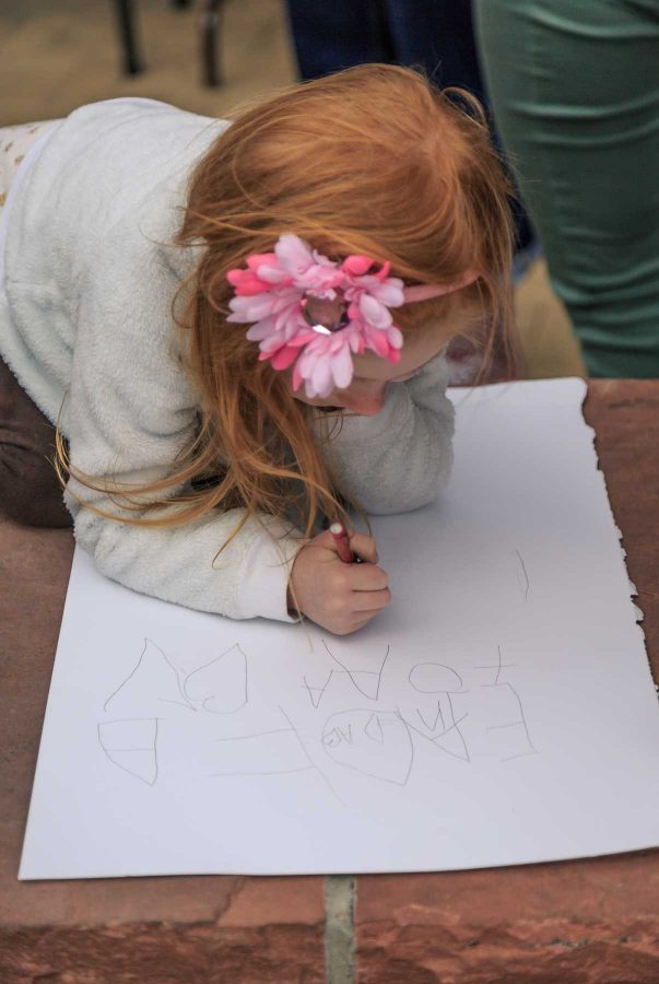 Imogene Stringer makes her own sign for the Planned Parenthood solidarity rally in Old Town Square.   Roughly 1,200 attended this event was organized by FoCo Local Girl Gang (Davis Bonner | Collegian)