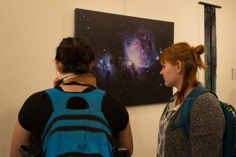 CSU student, Emily Pantoja, and a friend look at a photographic work in the Art and Science Exhibition in the Curfman Gallery.