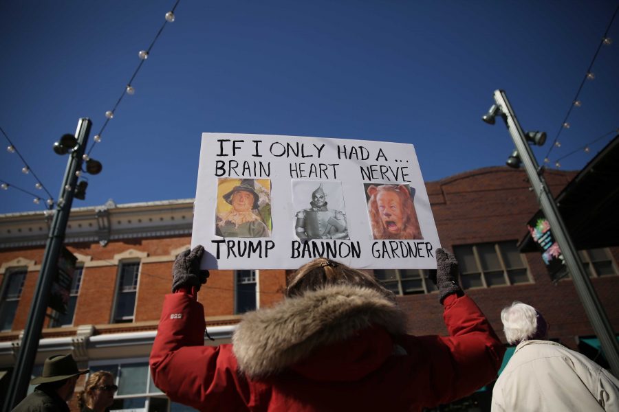 A protestor holds a sign poking fun at Donald Trump, Steve Bannon, and Cory Gardner during a rally against Cory Gardner, which aimed at making the political voices of the Fort Collins community heard. (Forrest Czarnecki | Collegian)
