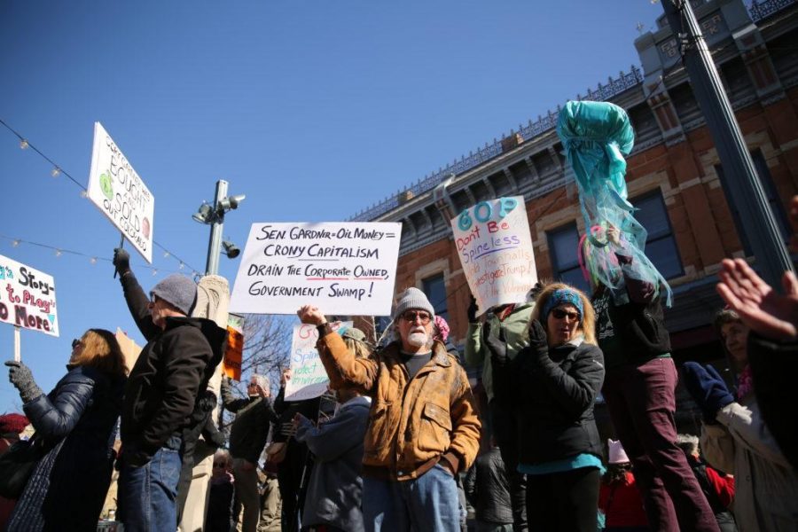 Protestors and activists display all types of political signs during a rally against Colorado Senator Cory Gardner in downtown Fort Collins on Sunday afternoon. (Forrest Czarnecki | Collegian)