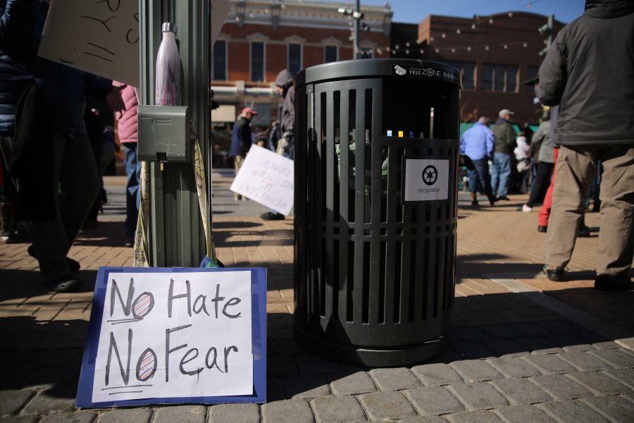 A political sign proposing acceptance and non-violent action is pictured during a rally against Colorado Senator Cory Gardner in downtown Fort Collins on Sunday afternoon. (Forrest Czarnecki | Collegian)