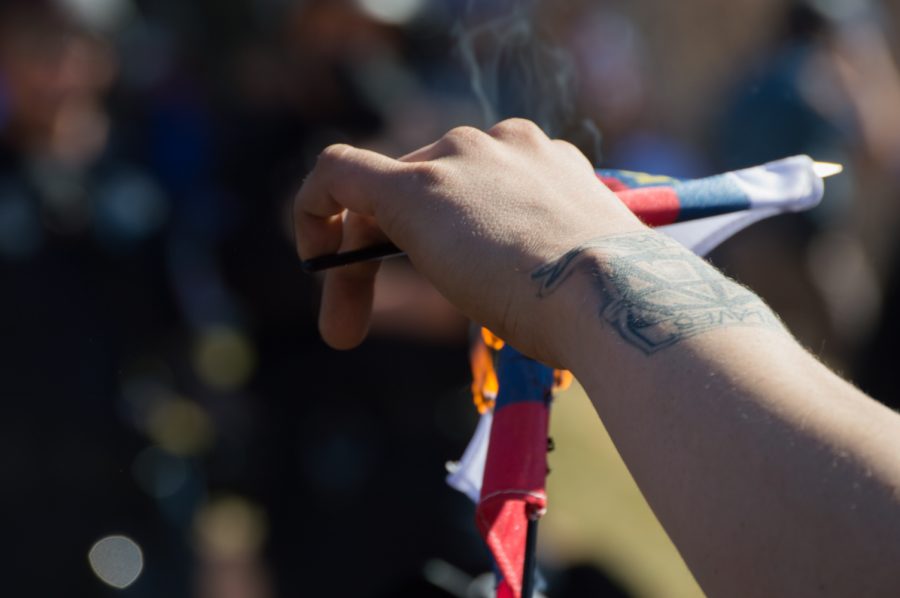 An ANTIFA protestor burns a Trump flag in demonstration at the March 4 Trump rally in Denver on Saturday. Photo by Kaitlyn Ancell | Collegian