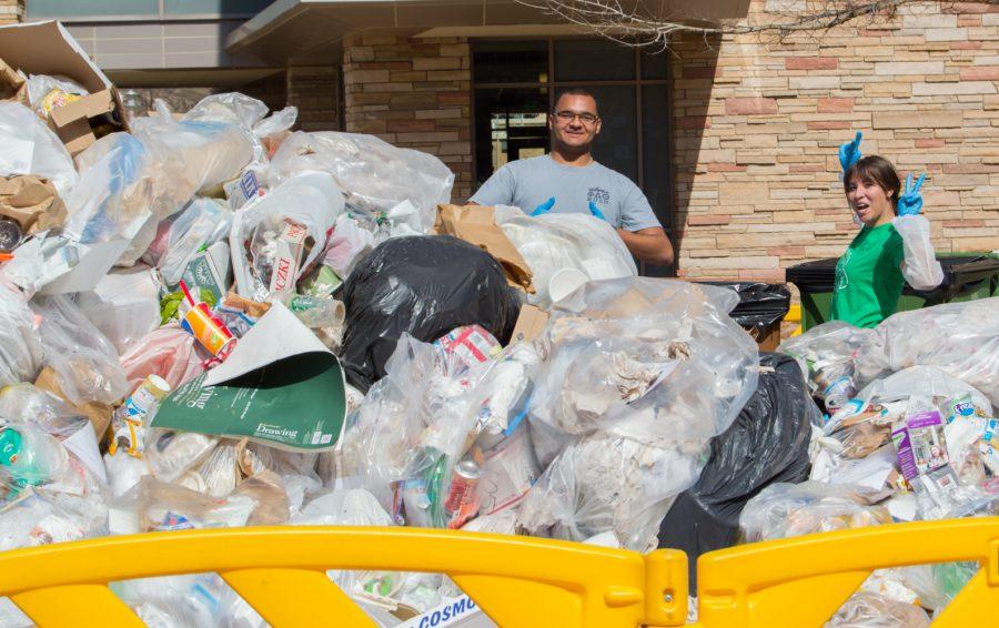 Evan Torres and Claire Crookston keep the smelly task of sorting through trash lighthearted at the Food Waste Audit on the plaza Wednesday. Photo by Kaitlyn Ancell | Collegian
