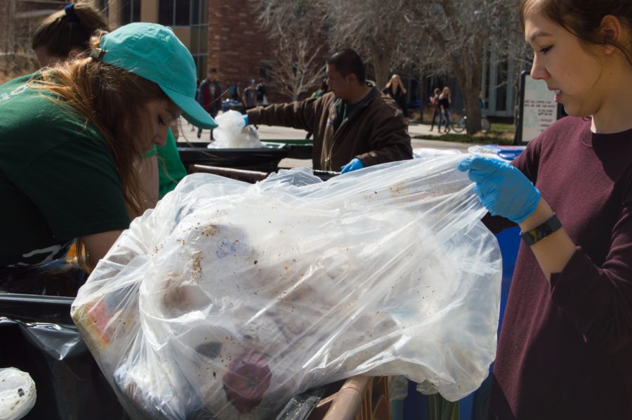 Cienna Semsak and Kirstye Tedrick and dig through trash at the Food Waste Audit on the plaza Wednesday morning. Photo by Kaitlyn Ancell | Collegian