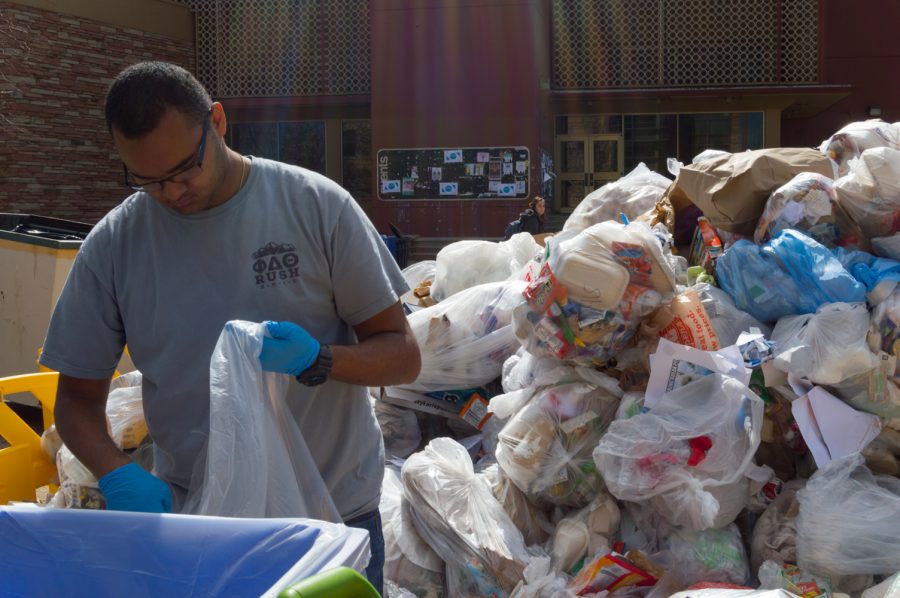 Evan Torres sorts through trash, recycleables, and compost materials at the Food Waste Audit last spring. (Collegian file photo)