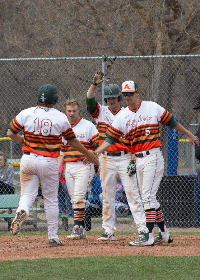 Junior, Mack Morford, receives high fives from his teammates after hitting a home run against Wyoming on Saturday. (Ashley Potts | Collegian)