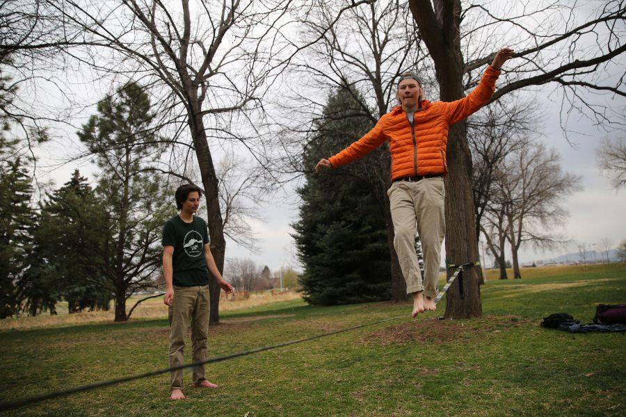 Colorado State University student Peter Kubly, seeking a Communications degree, practices his slacklining skills on Tuesday afternoon near Laurel Street while Daniel Chavez looks on. (Forrest Czarnecki | Collegian)