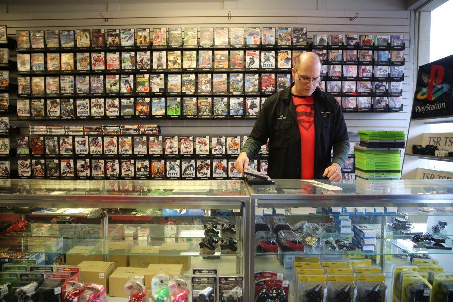 Victor Galey, the manager at Buy Back Games, does an inventory check on some video games while working on Tuesday afternoon. Some of the businesses along Elizabeth Street have been affected by the construction happening at the intersection of Shields and and Elizabeth Streets. (Forrest Czarnecki | Collegian)