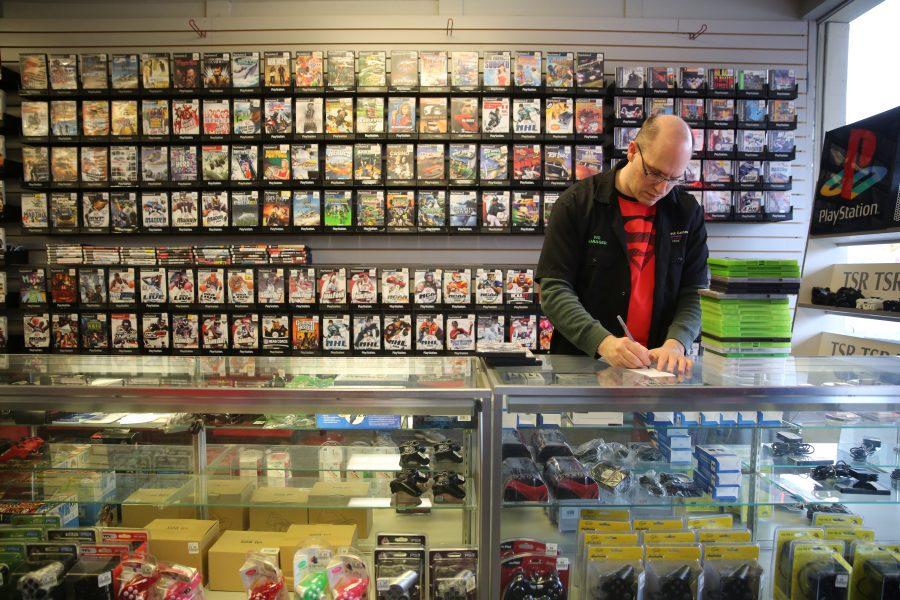 Victor Galey, the manager at Buy Back Games, does an inventory check on some video games while working on Tuesday afternoon. Some of the businesses along Elizabeth Street have been affected by the construction happening at the intersection of Shields and and Elizabeth Streets. (Forrest Czarnecki | Collegian)