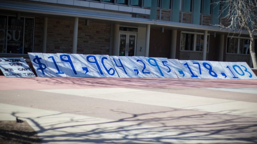 CSU students Andrew Walter and Zachary Taylor set up billboards with the national debt number to raise awareness of the national debt in the United States (Julia Trowbridge | Collegian)