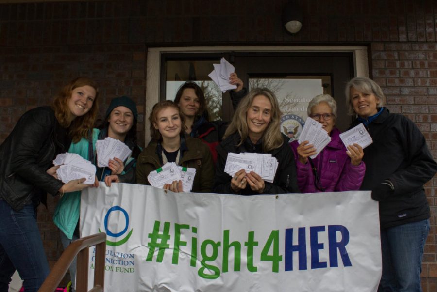 Members of Fort Collins chapter of Fight4Her stand in front of Cary Gardners office with their 1200 signed petitions in support of the Global HER Act. (Ashley Potts | Collegian)