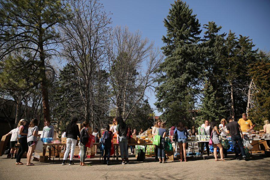 People work their way down tables lined with food at an event put on by SLiCE and the Larimer County Food Bank on Thursday afternoon in front of the Sherwood Forest. The event was put on to help fight food insecurity at Colorado State University. (Forrest Czarnecki | Collegian)