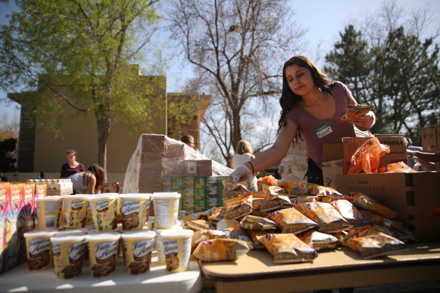 Colorado State University freshman Michelle Frias helps put food out on a table at an event organized by SLiCE and the Larimer County Food Bank on Thursday afternoon in front of the Sherwood Forest. The event was put on to help fight food insecurity at Colorado State University. (Forrest Czarnecki | Collegian)