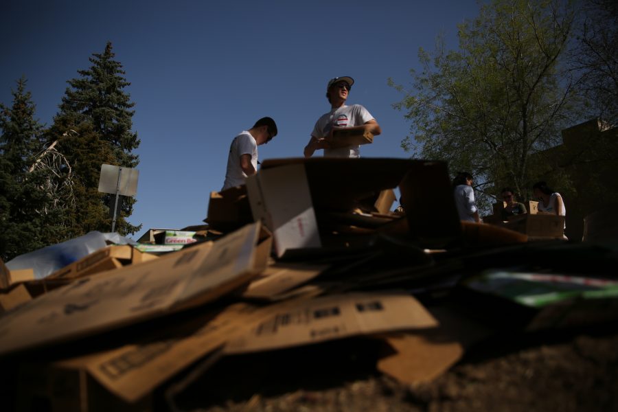 Colorado State University students Lance Gillespie, center, and Scott Laherran, left, break down cardboard boxes at an event organized by SLiCE and the Larimer County Food Bank on Thursday afternoon in front of the Sherwood Forest. The event was put on to help fight food insecurity at Colorado State University. (Forrest Czarnecki | Collegian)