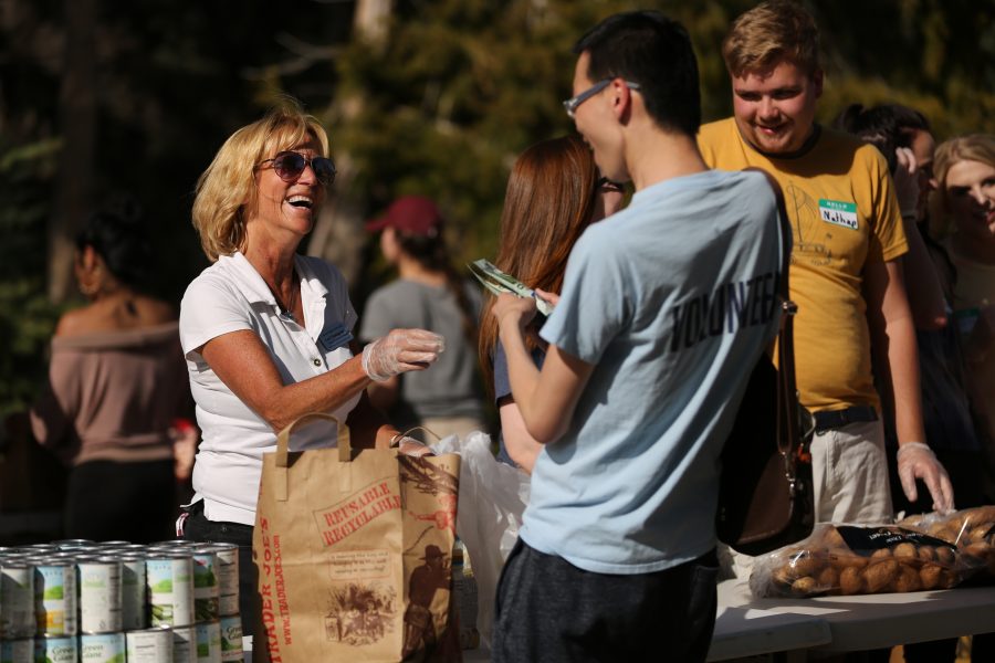 Lori Vanagunas, left, laughs and helps distribute food at an event organized by SLiCE and the Larimer County Food Bank on Thursday afternoon in front of the Sherwood Forest. The event was put on to help fight food insecurity at Colorado State University. (Forrest Czarnecki | Collegian)