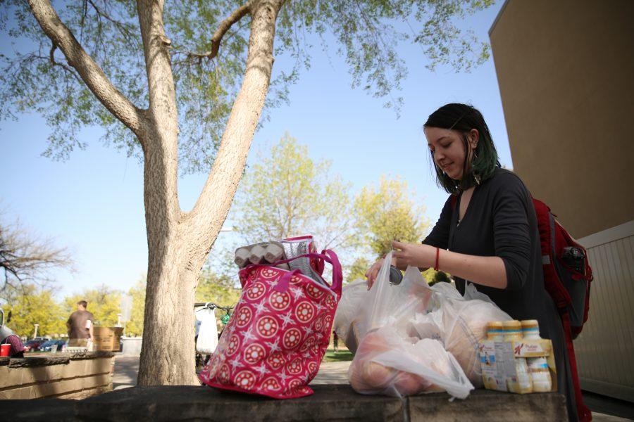 Colorado State University student Kassidy King gathers up all her food following an event organized by SLiCE and the Larimer County Food Bank on Thursday afternoon in front of the Sherwood Forest. The event was put on to help fight food insecurity at Colorado State University. (Forrest Czarnecki | Collegian)