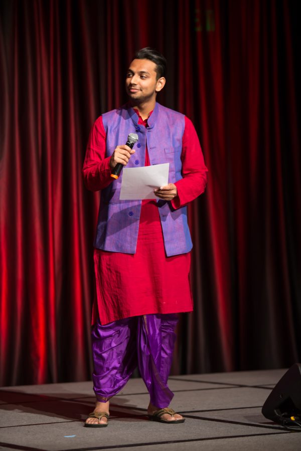 A representative from India joins a representative from Senegal to recite a poem together during the Council of International Student Affairs organized fashion show. (Davis Bonner | Collegian)