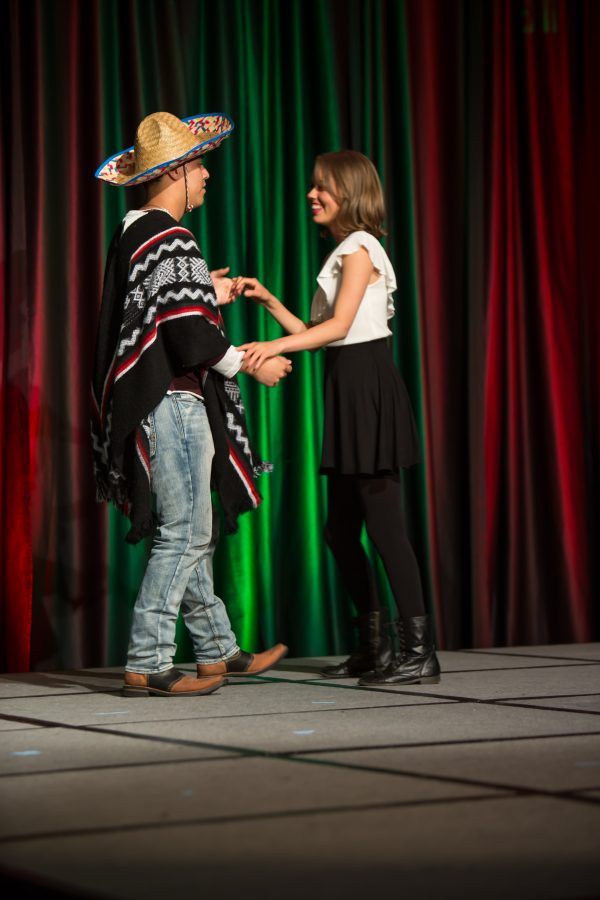 A representative from Mexico shares a dance with an audience member during the Council of International Student Affairs organized fashion show. (Davis Bonner | Collegian)