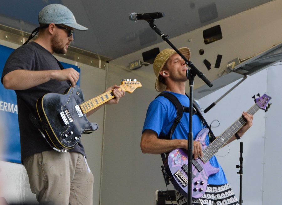 Band members Ian Gastl and Andrew Maloney of Tatanka vibe together onstage at their Lagoon Summer Concert Series Performance. Photo by Olive Ancell | Collegian
