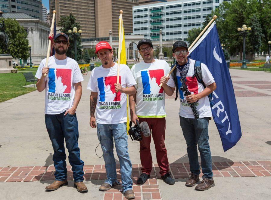 (From left to right) Logan Schwarz, Louis Huey, Glenn Flenniken and Seth Opperman, from the internet podcast Major League Libertarian, counter-protest the Trump Impeachment March amid heavy opposition. (Davis Bonner | Collegian)