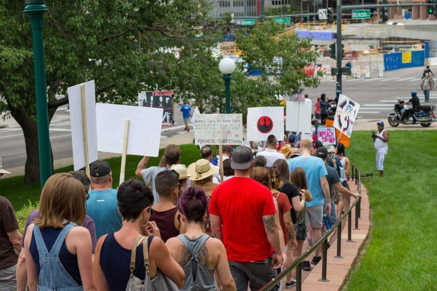 Protesters pass in front of the Colorado State Capitol during the Trump Impeachment March. (Davis Bonner | Collegian)