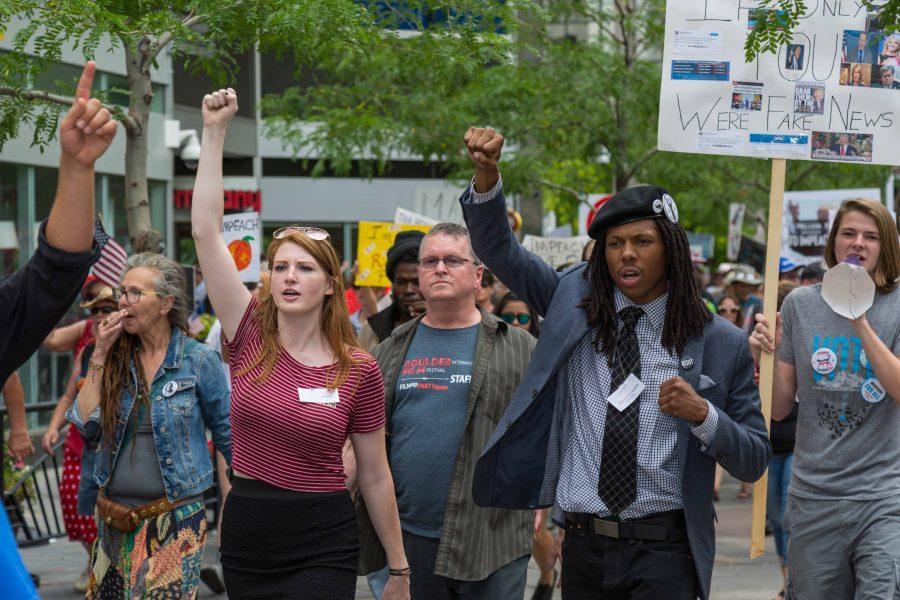 Samantha Montgomery, an organizer of the Trump Impeachment March, joins Quincy Shannon, right, in leading the protesters to Sen. Cory Gardners office. (Davis Bonner | Collegian)