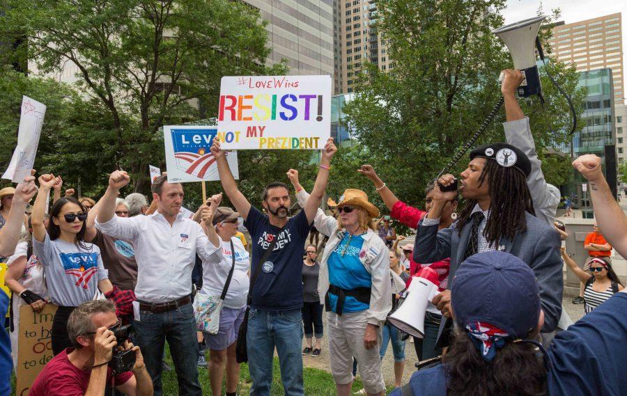 Quincy Shannon, right, speaks to the group of protesters gathered outside Sen. Cory Gardner's office during the Trump Impeachment March. (Davis Bonner | Collegian)