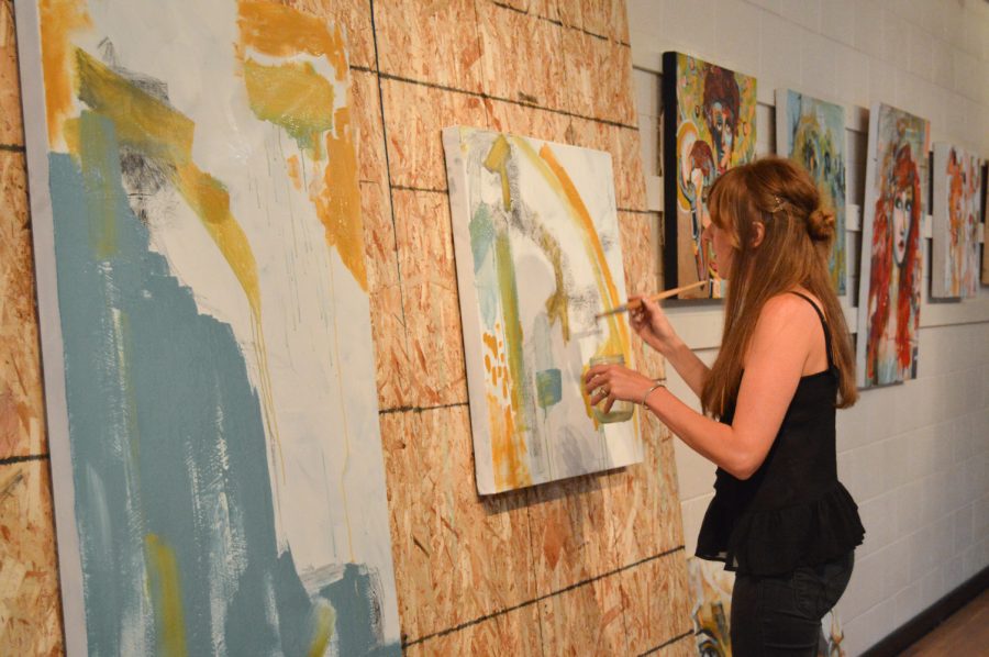 Ellie Light, artist and a communications professor at Colorado State University, performed a live painting at Bare Bones Haircuts Gallery at the First Friday Gallery Walk. Photo by Olive Ancell | Collegian