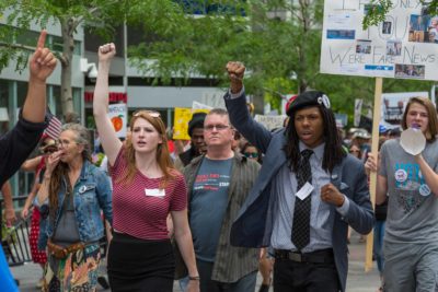 Samantha Montgomery, an of the organizer of the Trump Impeachment March, joins Quincy Shannon in leading the protesters to Cory Gardners office. (Davis Bonner | Collegian)