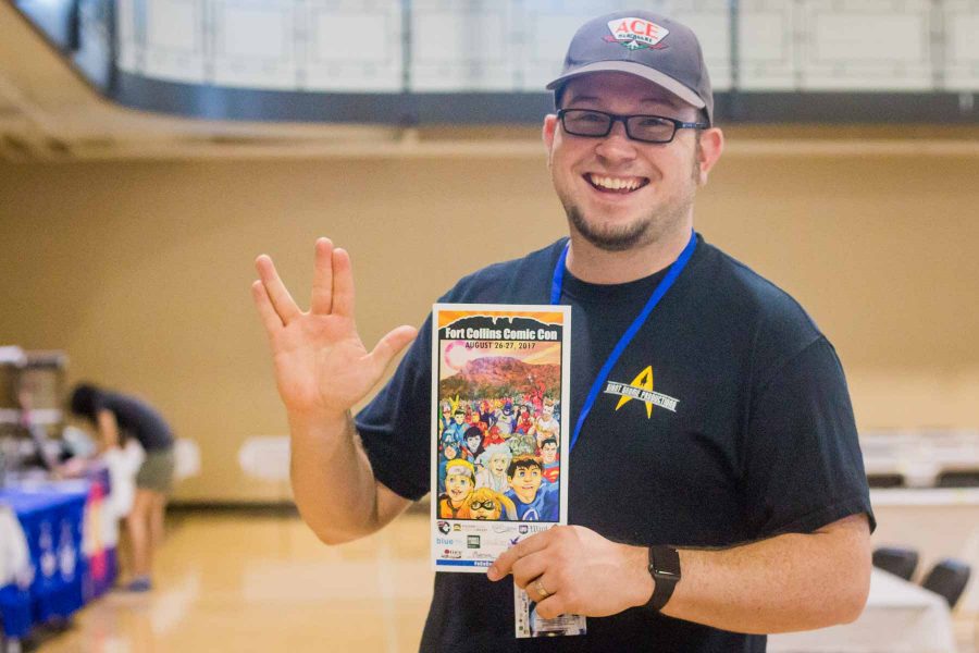 CSU alumni and co-organizer of Fort Collins Comic Con, Nick Armstrong throws up a Vulcan salute while holding the 2017 Fort Collins Comic Con program guide. 
(Cassie Alfaro | Collegian)