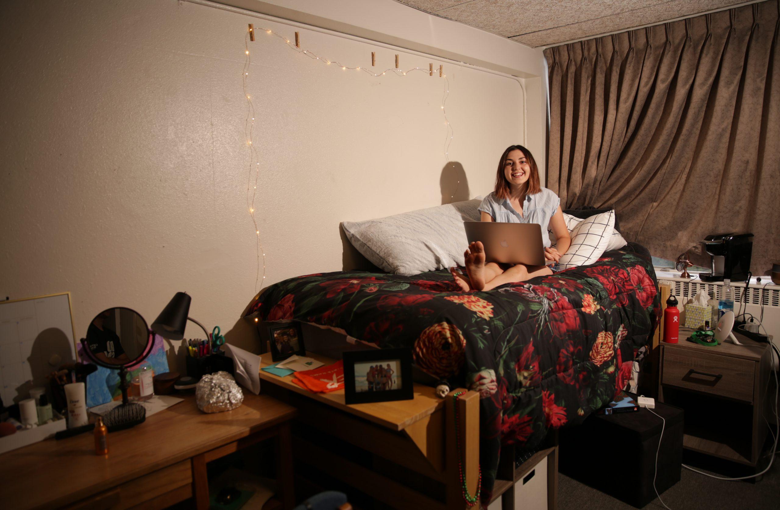 Madison Rogers sits on her bed inside her dorm room at Newsom hall.