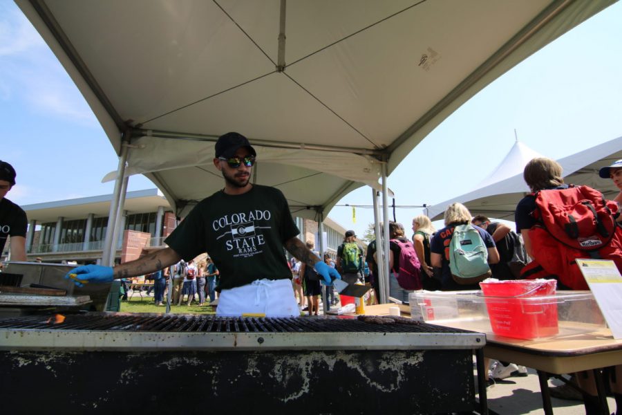 A volunteer flips burgers at the annual Grill the Buffs celebration before Fridays Rocky Mountain Showdown. (Joe Oakman | Collegian)
