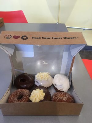 a half-dozen box of donuts including, peanut butter frosting, boston cream pie, two cinnamon sugar donuts, and a chocolate donut