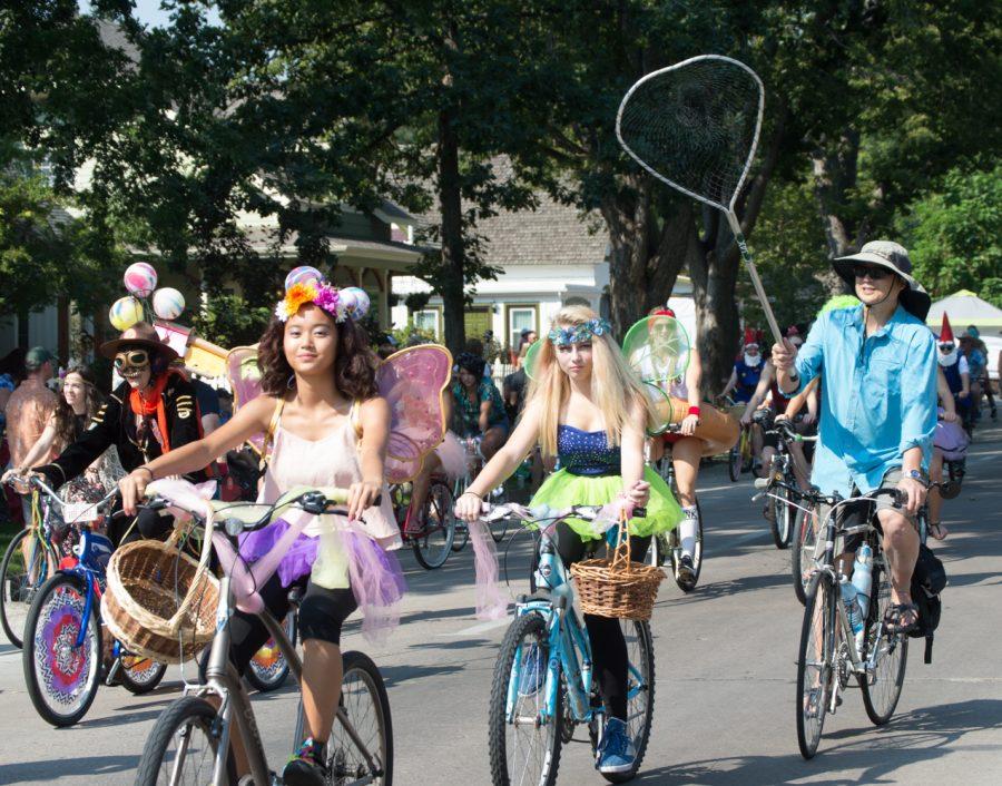 Two butterflies ride in the Tour de Fat parade Saturday afternoon, followed by their butterfly catcher. Photo by Olive Ancell | Collegian