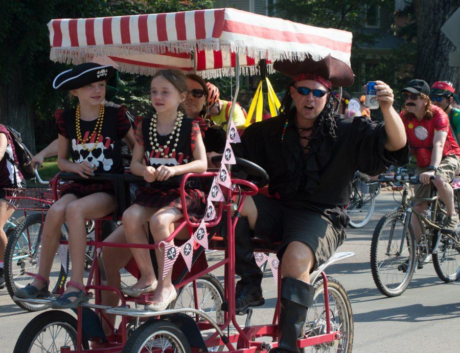 A family of pirates cruise along as the captain salutes spectators at Tour de Fat Satuday morning. Photo by Olive Ancell | Collegian