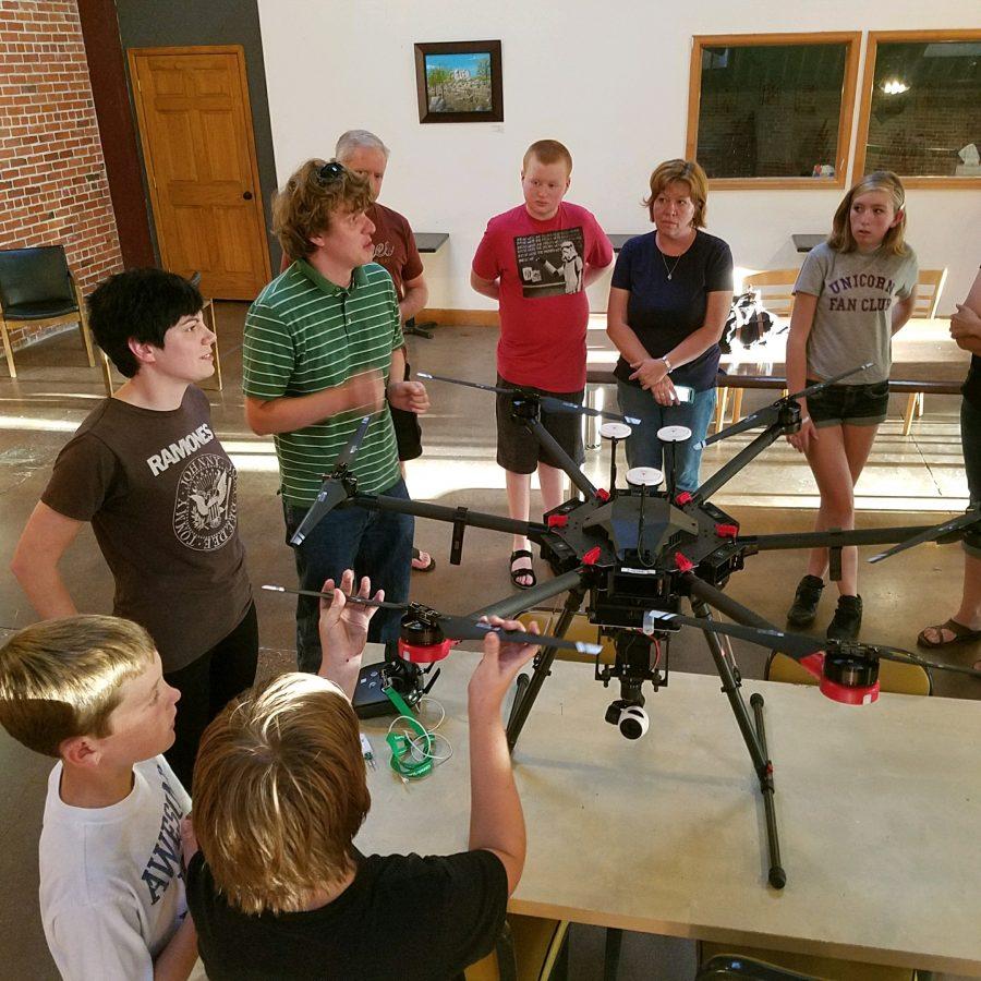 Students interact with a severe weather drone as graduate students answer questions.