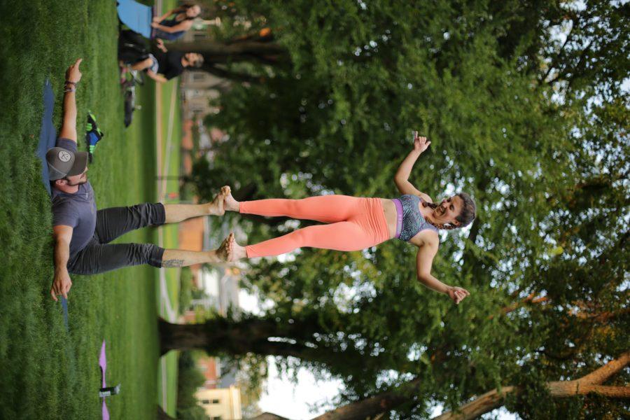 Colorado State University senior Mikaela Maldonado, top, and Garrett Dewey, bottom, perform an acroyoga pose during a yoga session at the Oval on the evening of September 7th. (Forrest Czarnecki | The Collegian)