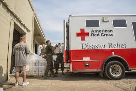 Disaster relief supplies being unloaded from a Red Cross vehicle.