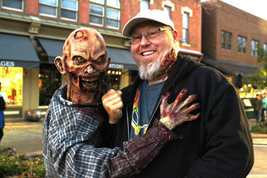 Mike Tamin of Fort Collins poses with his animatronic zombie at the 2017 Zombie Crawl in Old Town. (Sarah Ehrlich | Collegian)