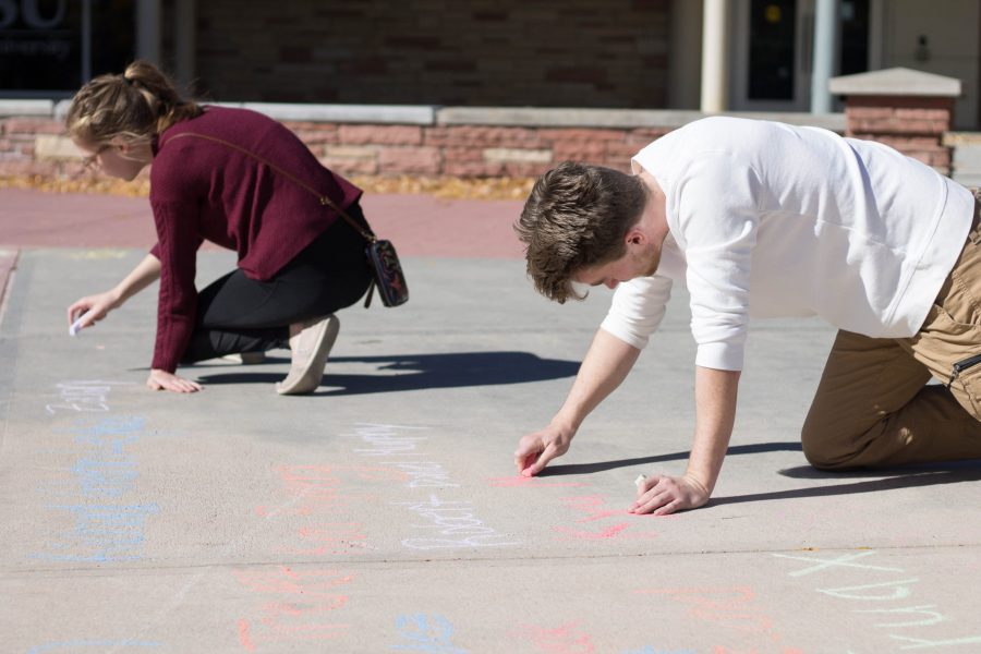 Michael Nagus, a freshman English major at Colorado State University, writes names of those killed by police in 2017 in Colorado at the Lory Student Center plaza on Oct. 22. The demonstration, organized by Ethnic Studies in Action, is aimed to raise awareness of police brutality. (Seth Bodine |Collegian)