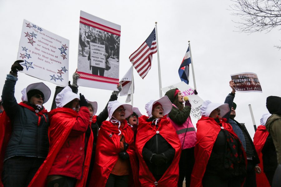 Protesters dressed as handmaids gather outside the Denver Marriott Tech Center where Vice President Mike Pence is to give a speech at a Republican Party fundraiser. The costumes are in reference to the popular television show Handmaids Tale that describes a world in which women are considered property. (Davis Bonner | Collegian)