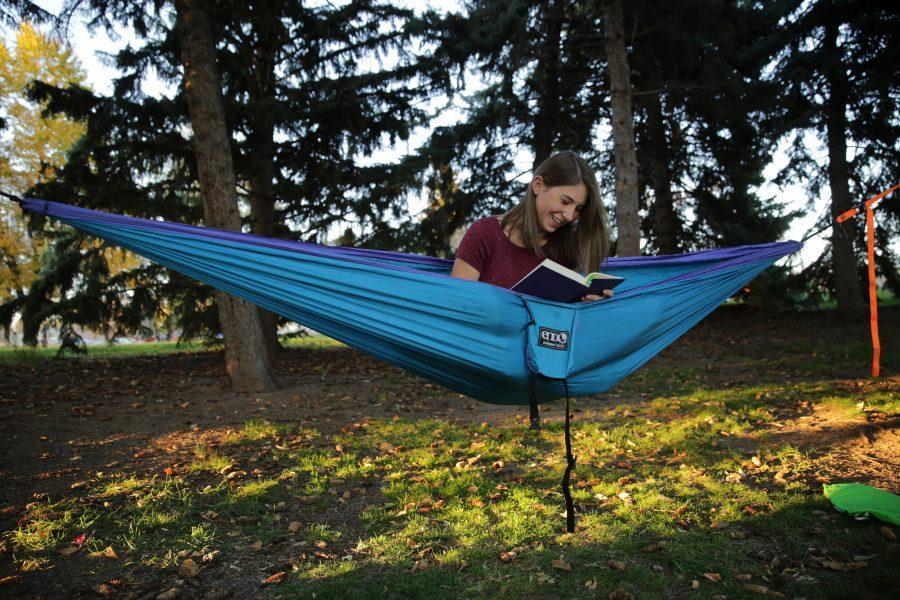 Bailey Richards, a first-year student at Colorado State University, reads while sitting in her hammock near the Lagoon on October 18, 2017. (Forrest Czarnecki | The Collegian)