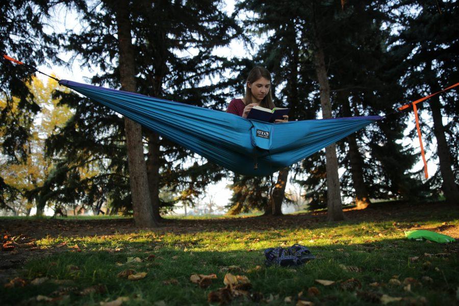 Bailey Richards, a first-year student at Colorado State University, reads while sitting in her hammock near the Lagoon on October 18, 2017. (Forrest Czarnecki | The Collegian)