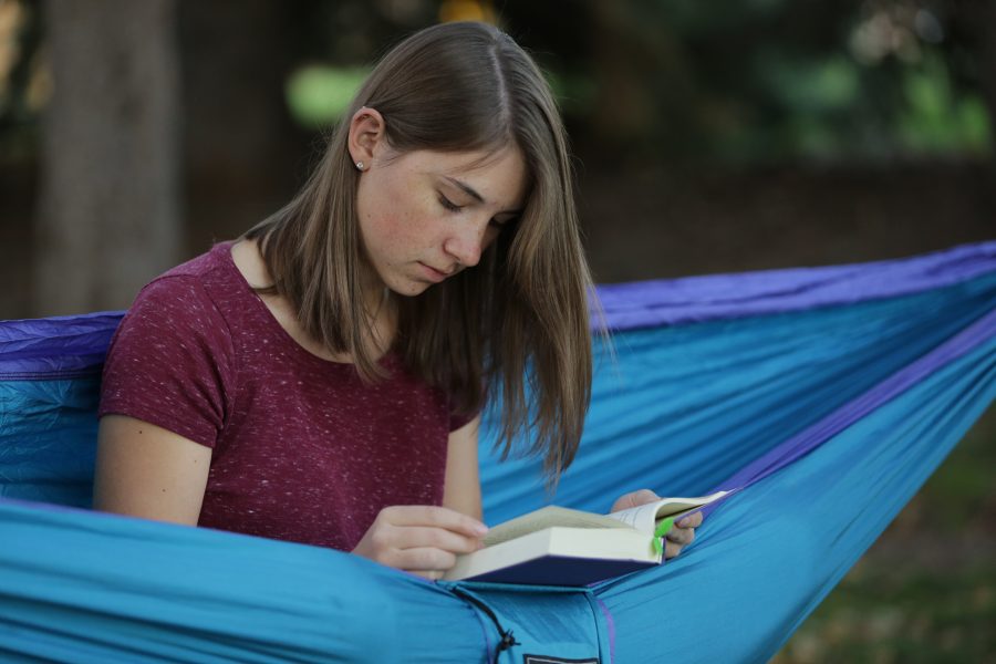 Bailey Richards, a first-year student at Colorado State University, reads while sitting in her hammock near the Lagoon on October 18, 2017. (Forrest Czarnecki | The Collegian)