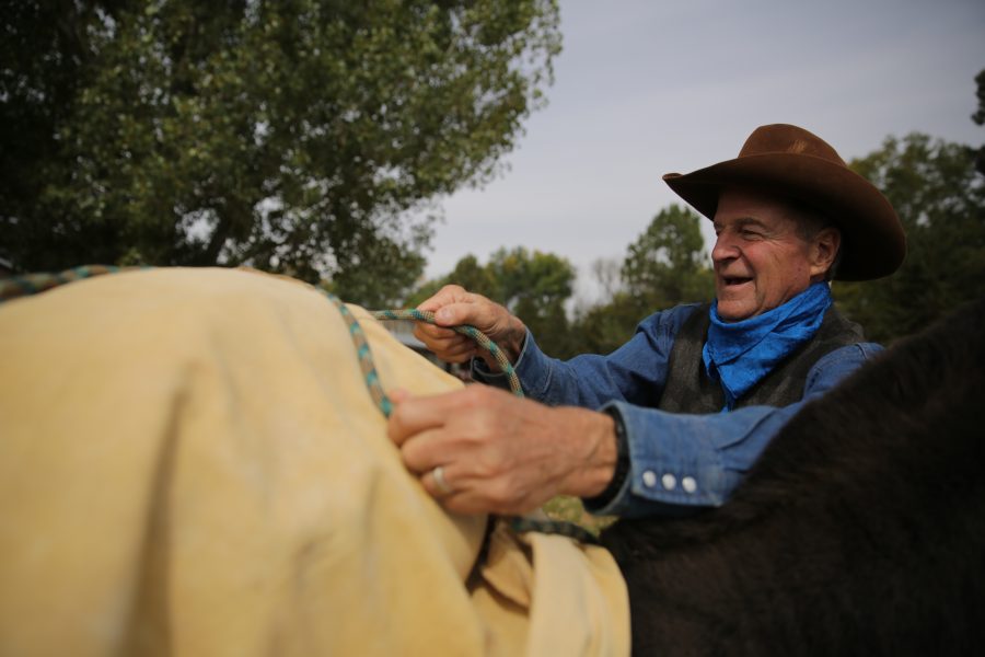 Rick Knight works on tightening a single diamond knot atop a pack saddle while attending a backcountry stock packing clinic at a ranch on the north end of Fort Collins on Saturday morning. Knight, a professor at Colorado State University, was attending a clinic being put on by George Wallace at Wallace's ranch north of town. The clinic covered how to set up and organize tack for backcountry excursions using stock such as mules and horses. (Forrest Czarnecki | The Collegian)