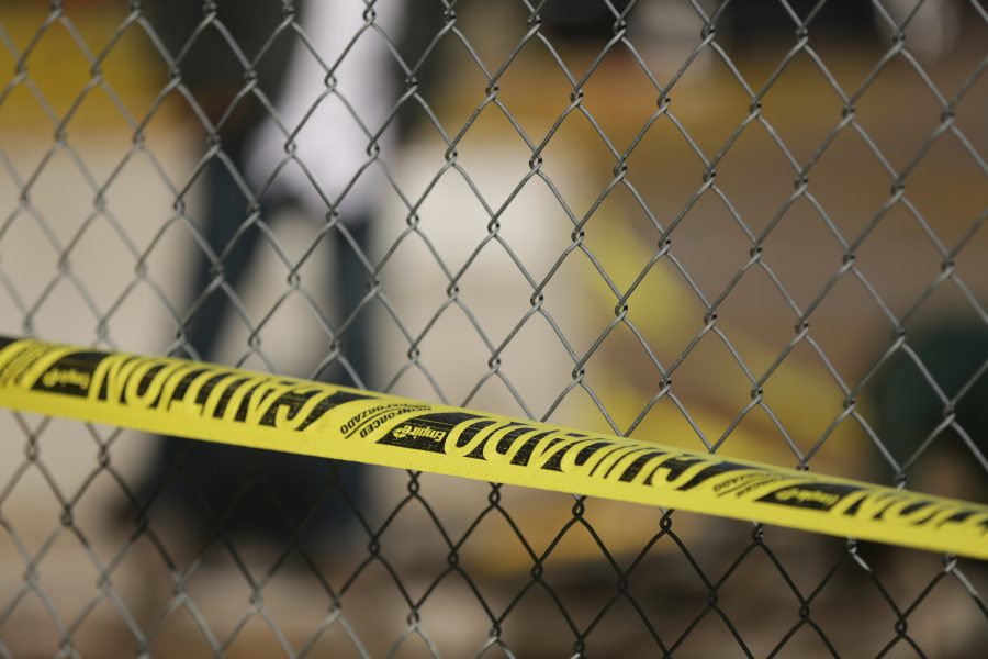 Yellow warning tape a chain-linked fence surround a construction zone along West Plum Street near the Colorado State University Transit Center on Tuesday morning. Workers were replacing and rerouting a condensation line underneath the roadway. (Forrest Czarnecki | The Collegian)