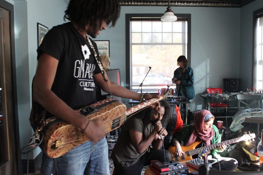 Four members of the band OneLabel are pictured while they rehearse one of their songs.
 in this rehearsal they play a song inspired by Kenyan tradition.
 (Brandon Mendoza | Collegian)