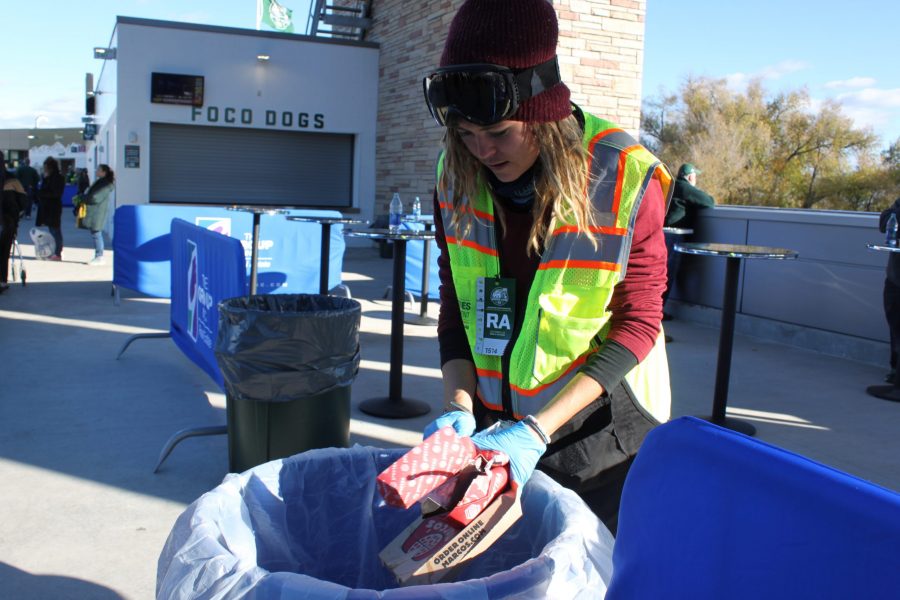 During the Colorado State vs. Air Force game, junior Maggie Gilman sorts compost from recycling material in one of the bins at the football stadium on behalf of the zero waste team. (Brandon Mendoza | Collegian)